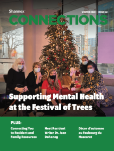 Winter 2022 cover of Shannex Connections magazine with five people sitting in front of a Christmas tree while wearing their masks