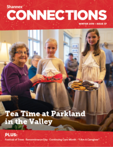Winter 2019 cover of Shannex Connections magazine with two children holding a assortment of treats towards a resident